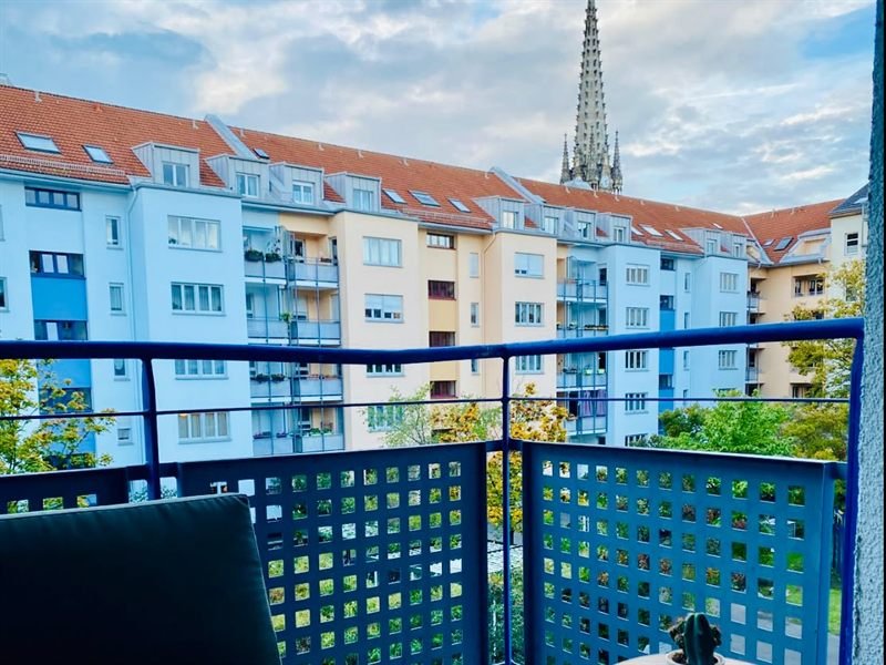Balkon mit Sitzecke und Blick über die Nachbarhäuser bis zu einem Kirchturm in Leipzig-Zentrum-Süd